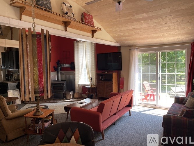 A living room with a red couch and a television.