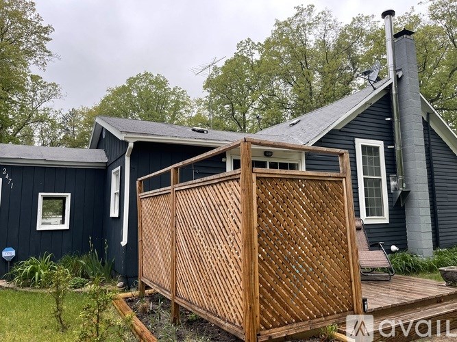 A wooden gate in front of a black house.