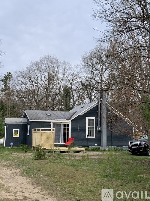 A blue house with a car parked in front.