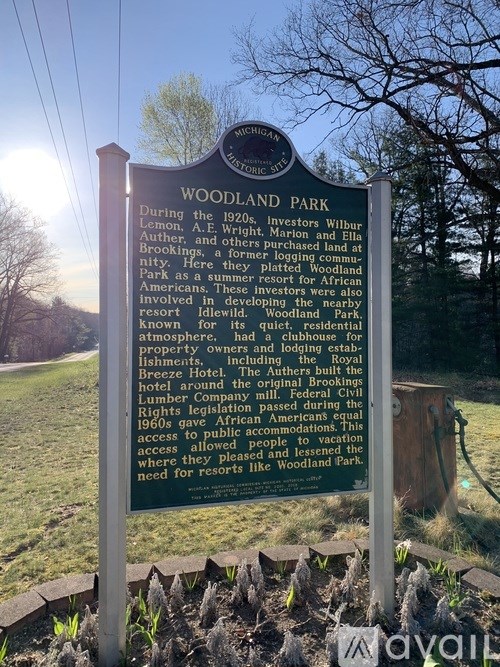 A sign in front of a tree that says Woodland Park.