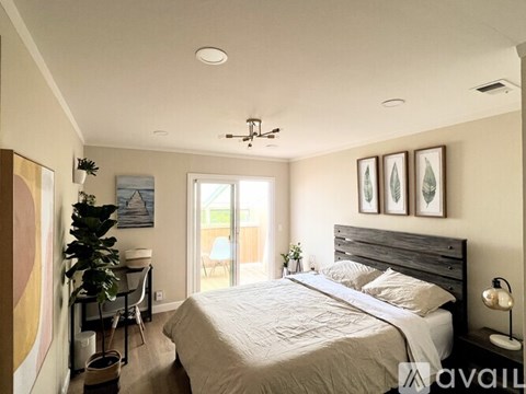 A bedroom with a large bed and a ceiling fan.