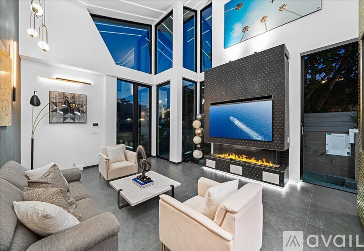 A modern living room with a large flat screen TV and a fireplace.