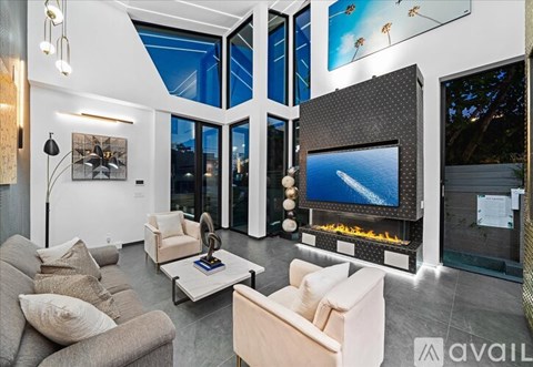 A modern living room with a large flat screen TV and a fireplace.