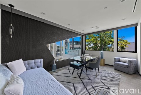A modern bedroom with a large bed and a glass table.