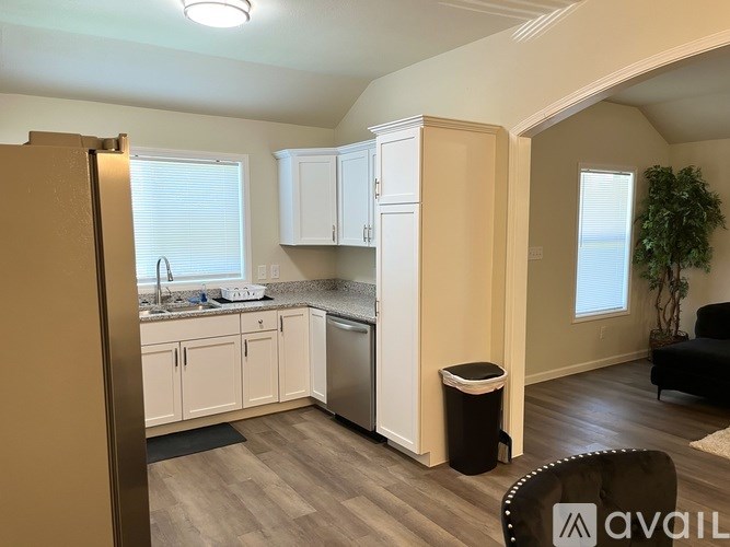 A kitchen with white cabinets and a black fridge.