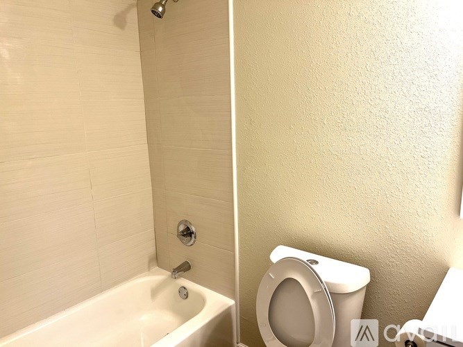 A white toilet is next to a bathtub in a bathroom.