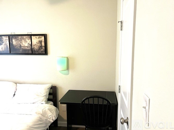 A bedroom with a bed, desk, and chair.