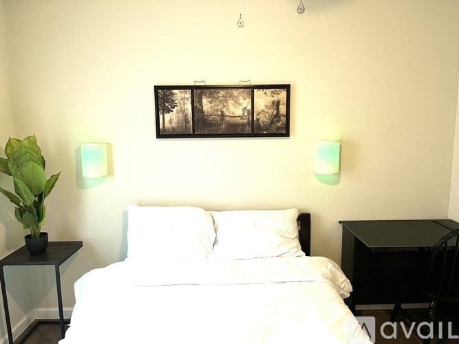 A bedroom with a bed, nightstand, and two lamps.