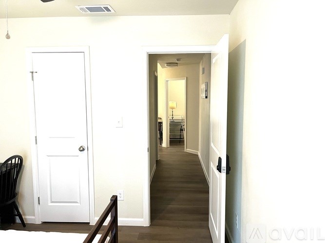 A hallway with a white door and a wooden railing.