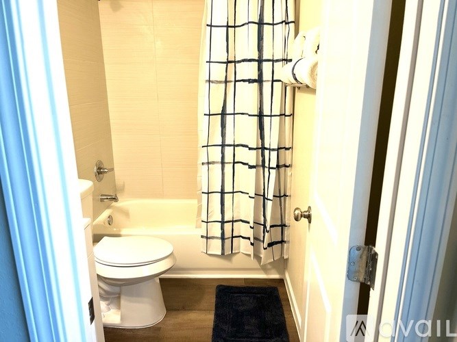 A bathroom with a toilet, sink, and shower curtain.