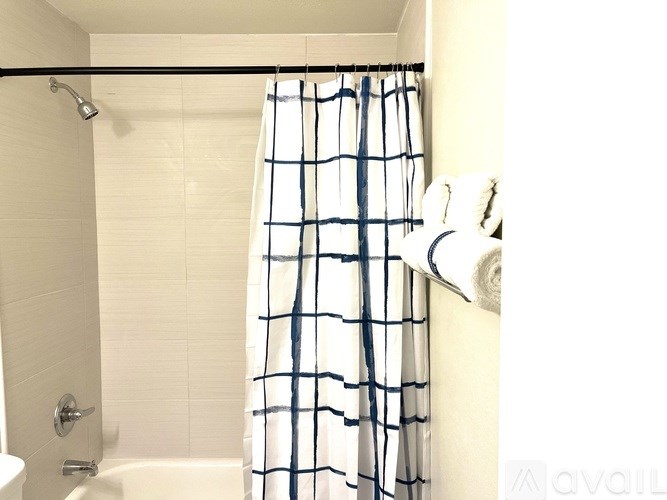 A white and blue shower curtain hangs in a bathroom.