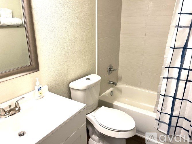 A white toilet sits next to a white sink in a small bathroom.