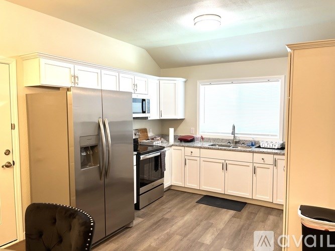 A kitchen with a refrigerator, oven, and sink.