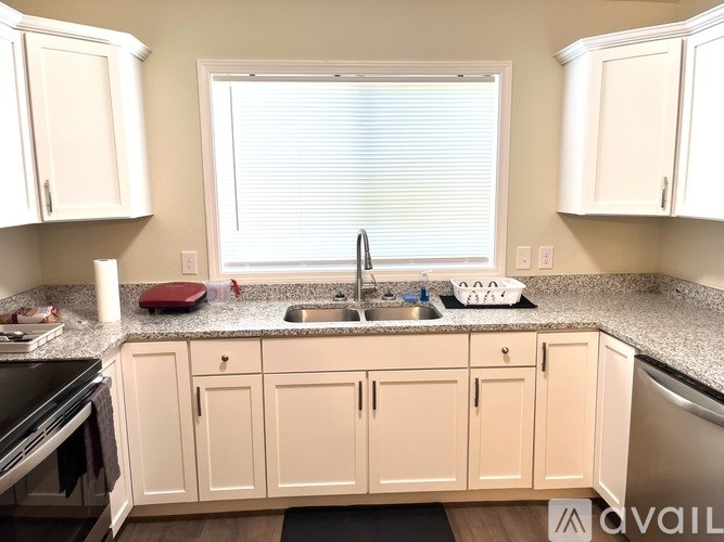 A kitchen with white cabinets and a granite countertop.