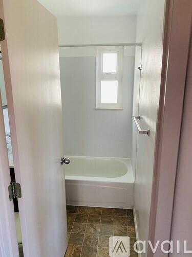 A bathroom with a tub and a window.