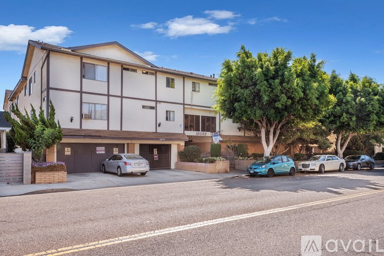 A modern two-story building with a parking lot in front.