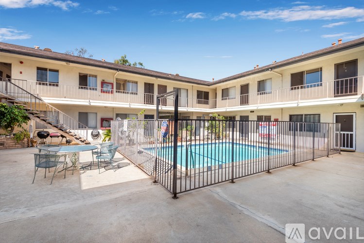 A pool surrounded by a black fence in a courtyard.