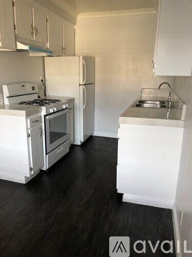 A black car is parked in a large, empty garage.