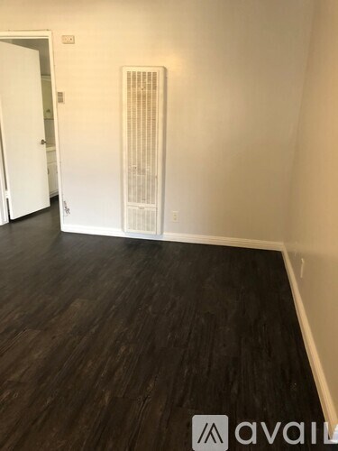 A room with a wooden floor and a white radiator.