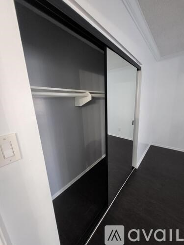 A black and white hallway with a glass door and a white wall.