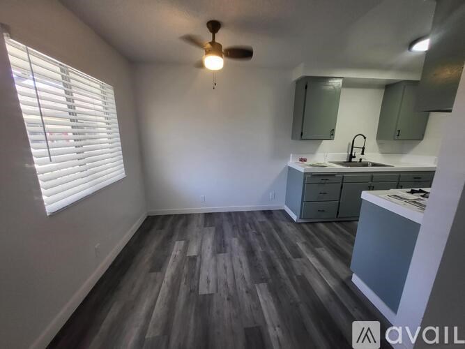 A room with a ceiling fan and a sink.