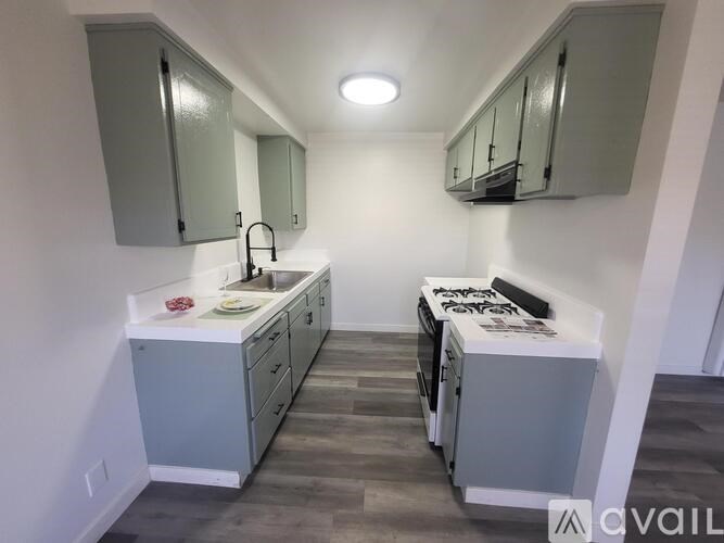 A kitchen with a white countertop and grey cabinets.