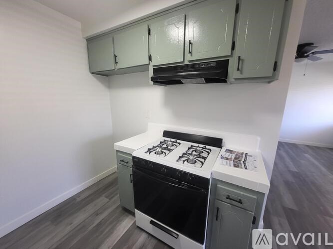 A kitchen with a stove top oven and a wall-mounted cabinet above it.