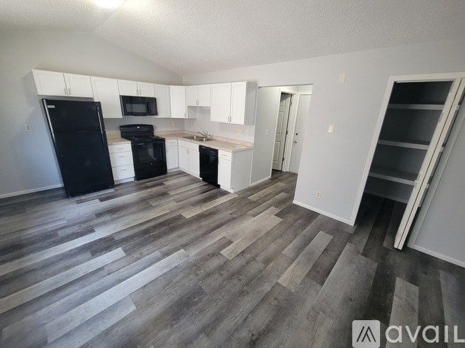 A kitchen with black appliances and white cabinets.