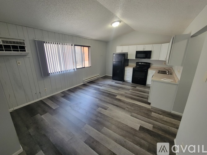 A room with a white door, a white cabinet, and a white wall.