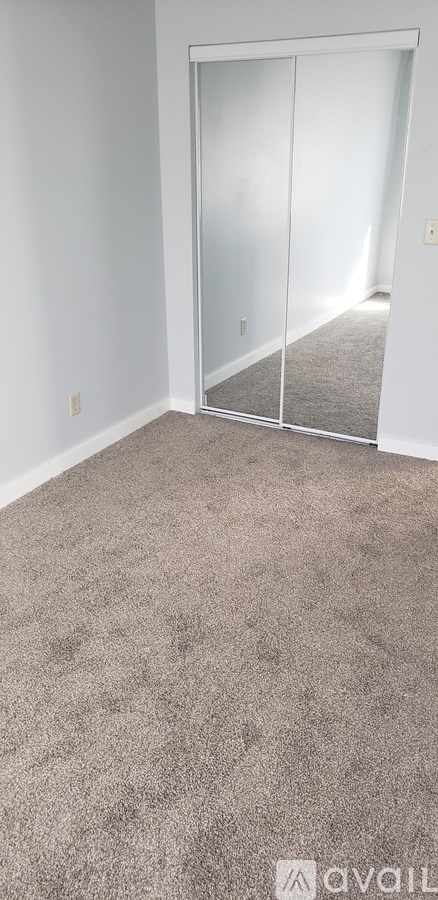 A room with a carpeted floor and a glass door.