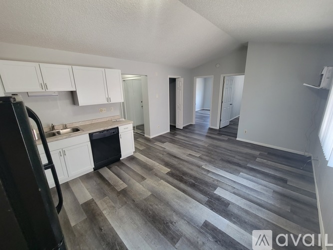 A kitchen with black appliances and a refrigerator.