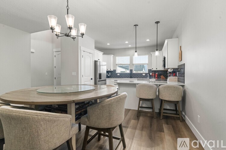 A modern dining room with a round table and chairs.