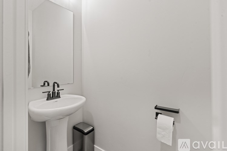 A white sink with a mirror above it and a towel rack to the side.
