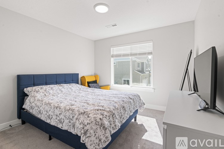 A bedroom with a bed, a television, and a window.