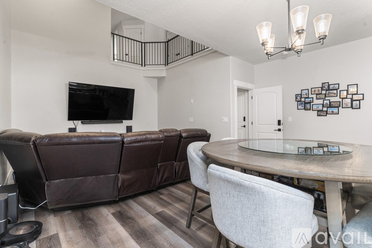 A living room with a brown leather couch and a television.