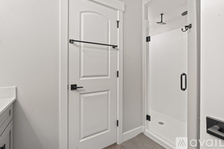 A white bathroom with a door and a shower.