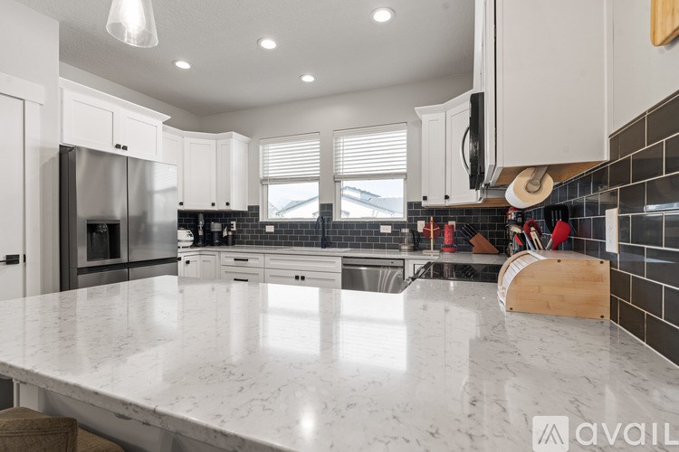 A modern kitchen with a marble countertop and stainless steel appliances.