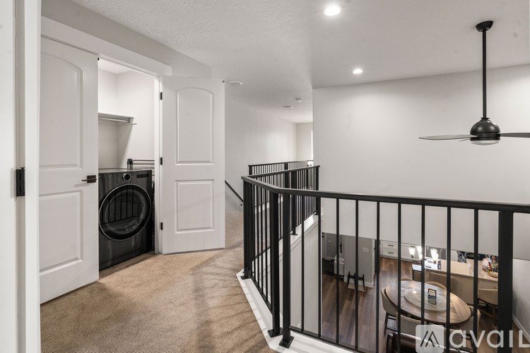 A balcony with a black railing and a ceiling fan.