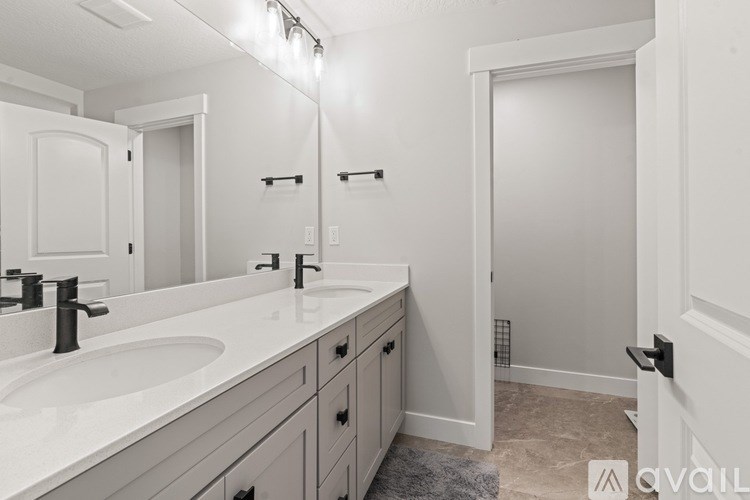 A bathroom with a sink, mirror, and a shower.