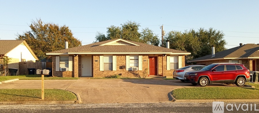 A house with a red car parked in front.