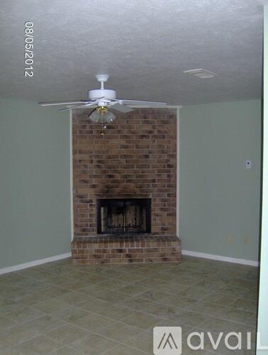 A room with a fireplace and a ceiling fan.