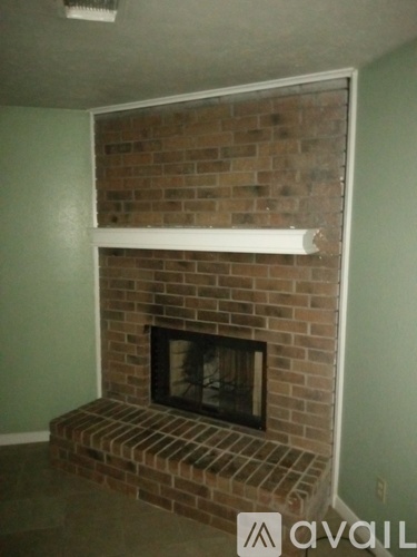 A brick fireplace with a white mantle.