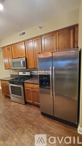 A kitchen with wooden cabinets and a stainless steel refrigerator.