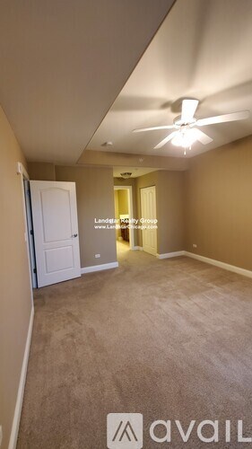 A room with a carpeted floor and a ceiling fan.