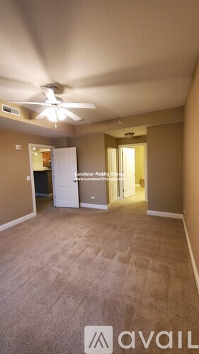 A room with a carpeted floor and a ceiling fan.