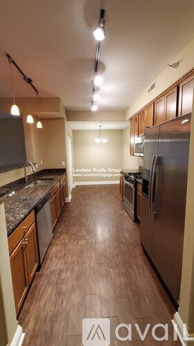 A kitchen with wooden floors and stainless steel appliances.