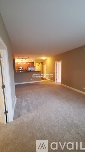 A room with a carpeted floor and a door leading to another room.