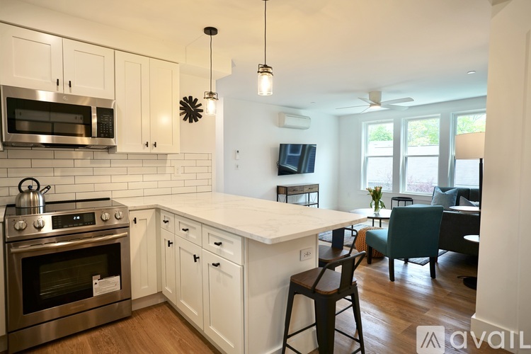 A kitchen with white cabinets and a stainless steel oven.