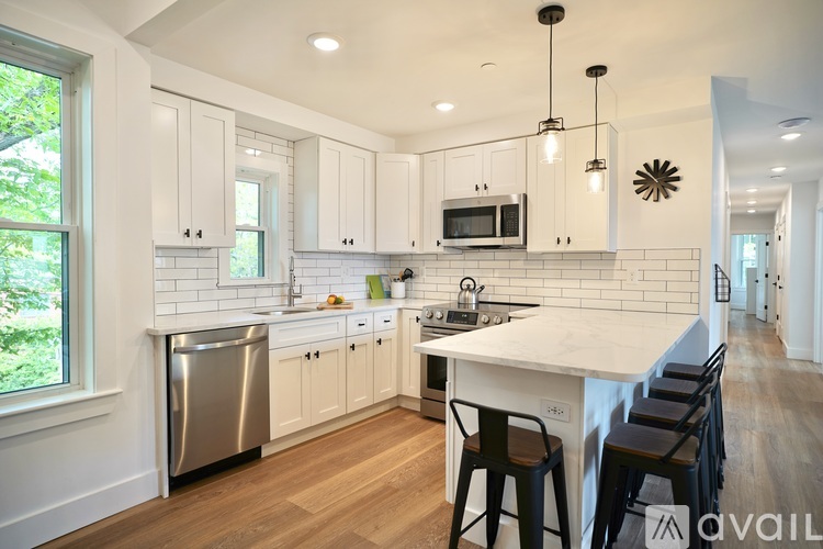 A kitchen with white cabinets and a white counter top.