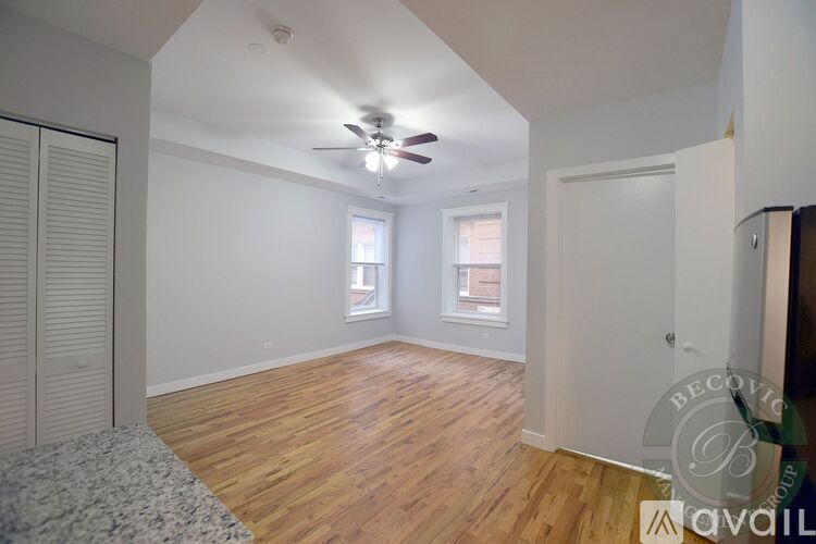 A room with wooden floors and a ceiling fan.